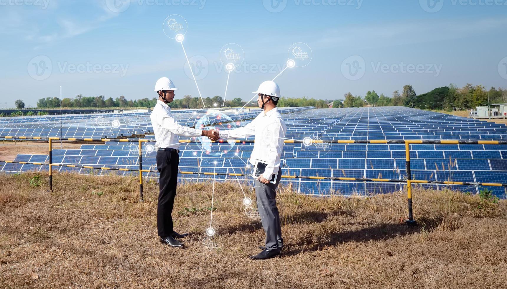 Aziatische zakenlieden staande check hand met het zonnepaneel op de achtergrond. het idee van investeerders is om samen te werken in het bedrijfsleven op het gebied van hernieuwbare energie om hun investeringen over de hele wereld uit te breiden foto