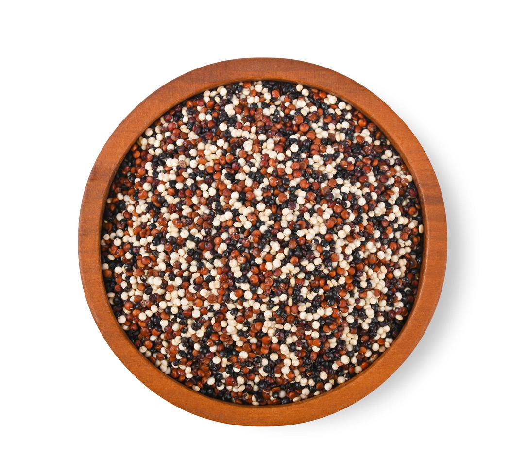 quinoa zaden in houten kom geïsoleerd op een witte achtergrond. bovenaanzicht foto