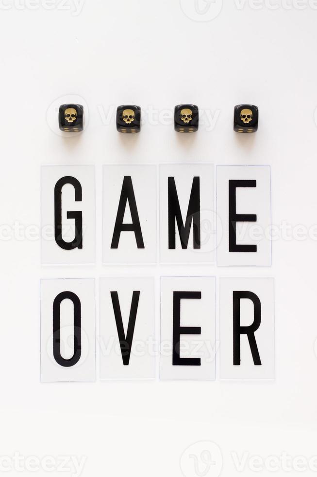 game over tekst en gaming dobbelstenen met afbeelding schedel op witte achtergrond. concept voor banners, webpagina's, games, presentatie. bovenaanzicht foto