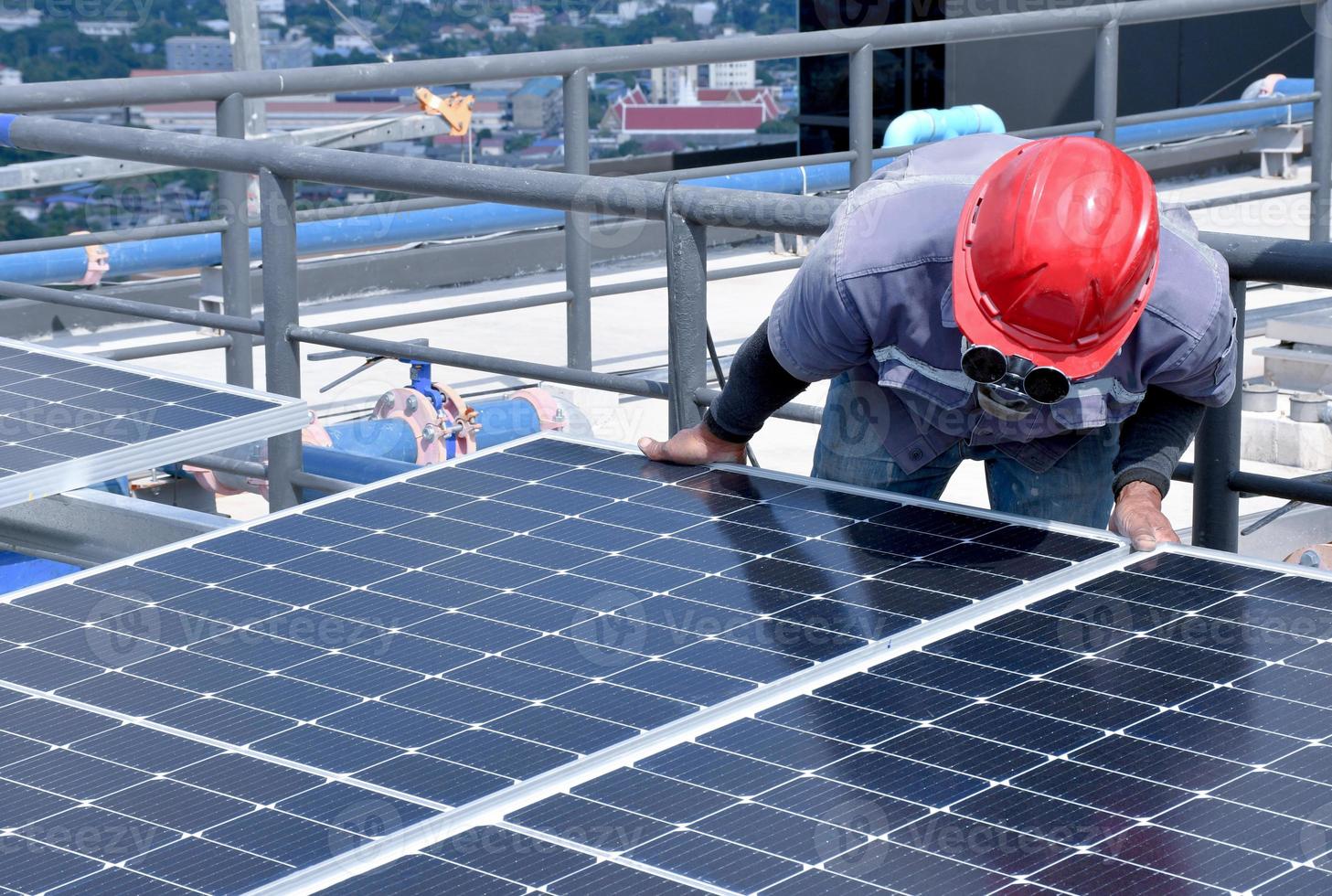 de monteur installeert de zonnepaneelcel met elektrische boor op het dak. foto