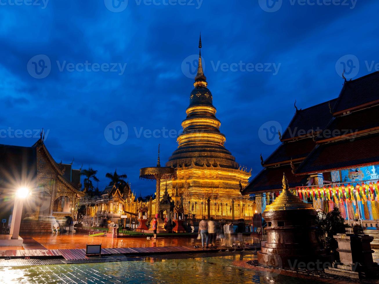gouden pagode in wat phra that hariphunchai tijdens honderdduizend lantaarnfestival in lamphun boeddhistische aanbidding met donkerblauwe lucht, lamphun, thailand. foto