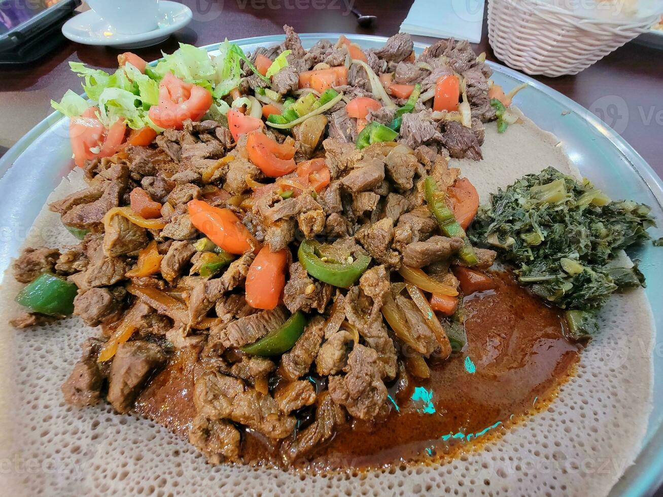 Ethiopisch eten injera brood met biefstuk en tomaten foto