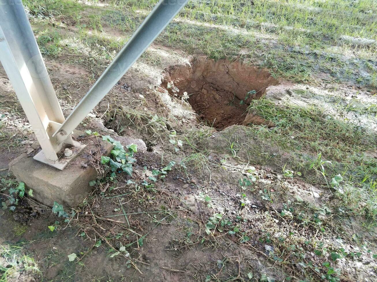 groot gat in het vuil en de metalen structuur foto