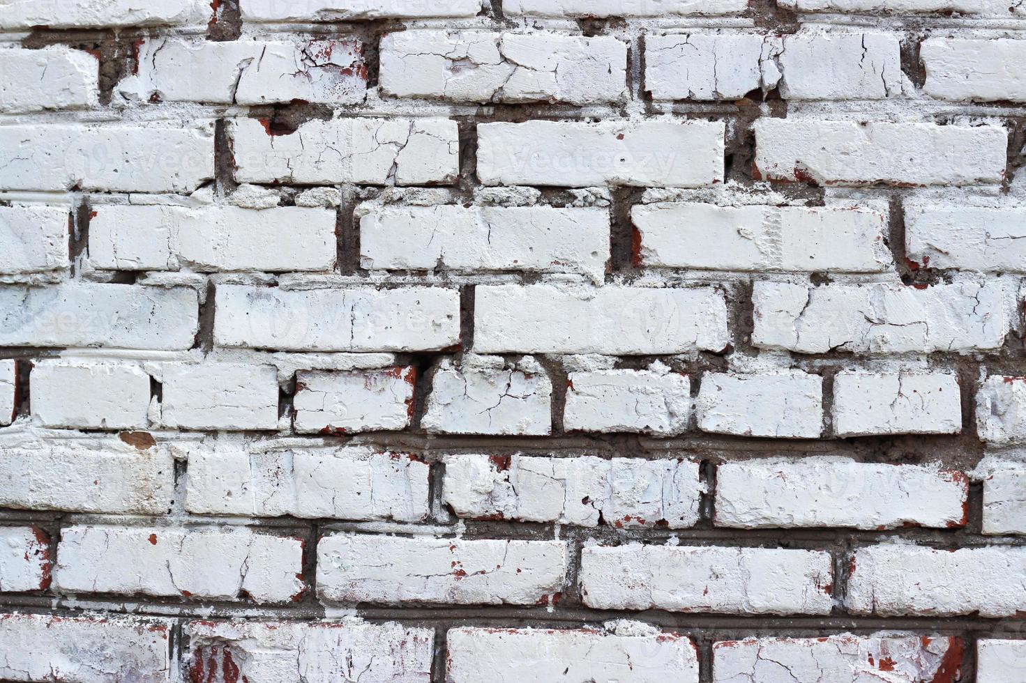 de textuur van rode baksteen geschilderd met witte gebarsten verf. oude muur. foto