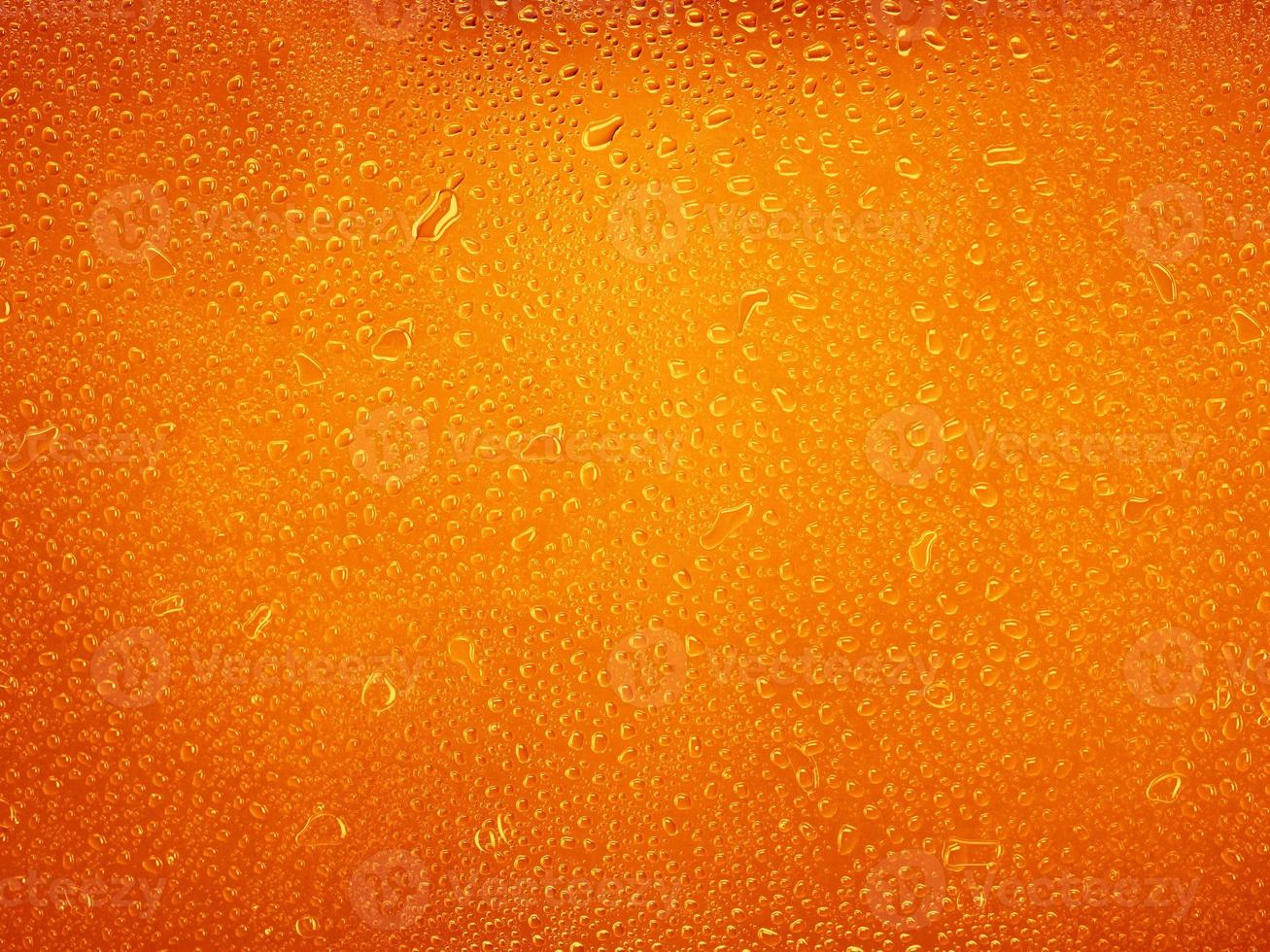 waterdruppels op oranje achtergrondstructuur. achtergrond glas bedekt met druppels water foto