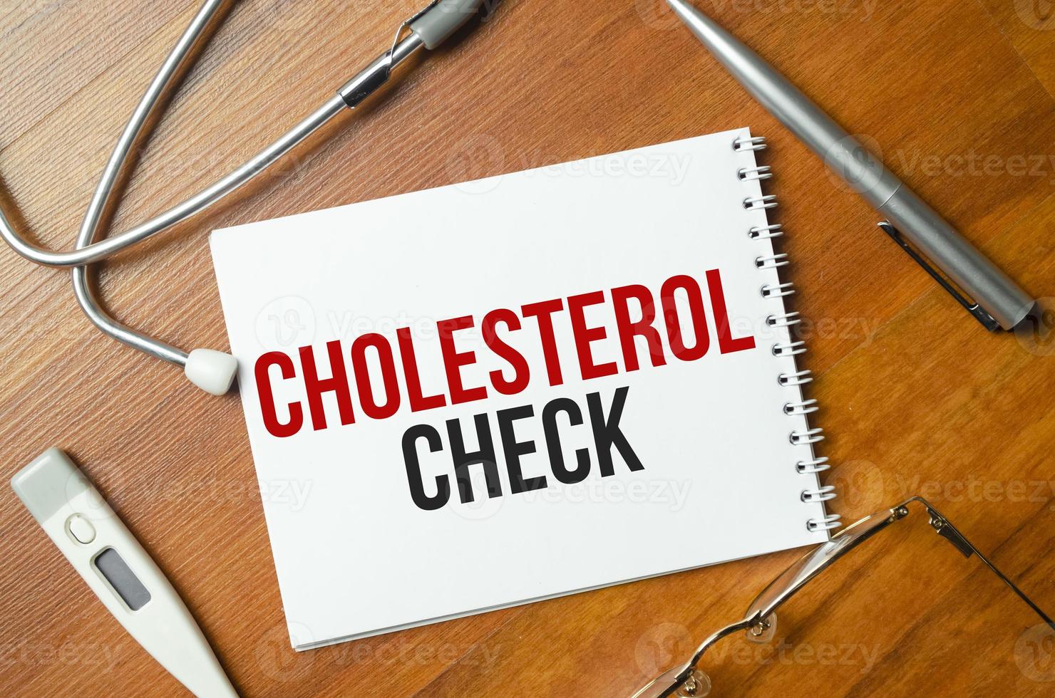 cholesterolcontrole met pen en stethoscoop op houten achtergrond foto