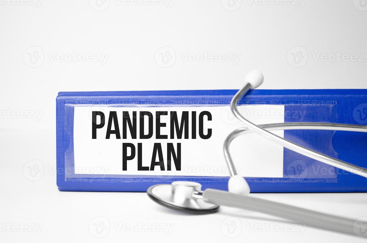 pandemisch planwoord geschreven op blauwe bestandsmap naast een stethoscoop foto