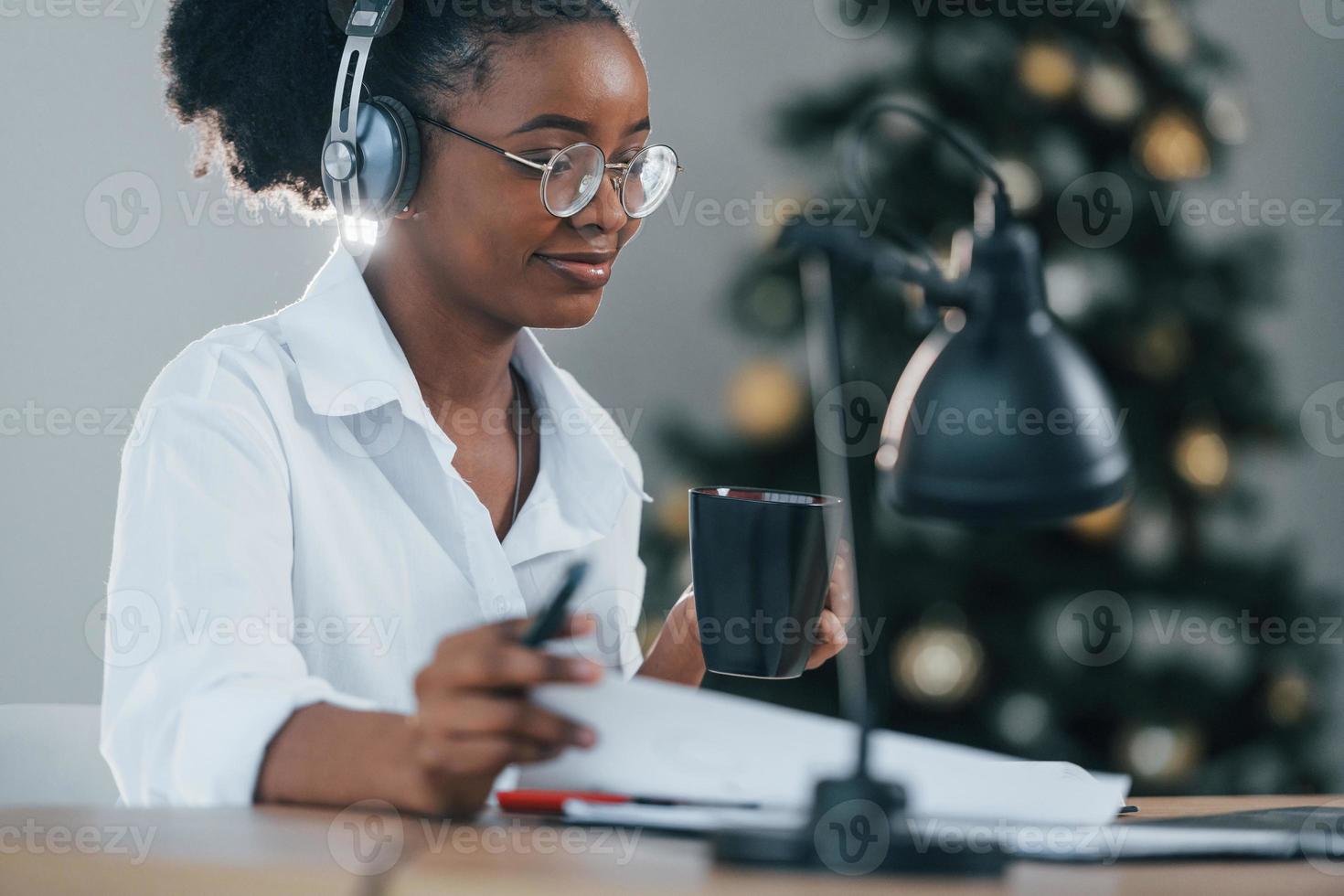 druk bezig met online bestellen. jonge Afro-Amerikaanse vrouw in wit overhemd is thuis foto