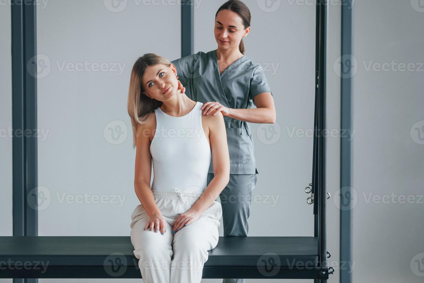 nek oefeningen. vrouw is in gezondheidscentrum en krijgt hulp van dokter foto