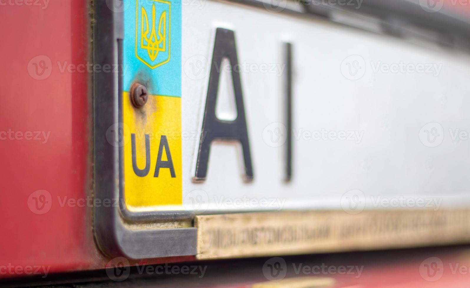 Oekraïens autoregistratienummer met nationale vlag en wapenschild. regiocode, kiev regio ai, 10 regio. autonummer zonder nummers op de voorbumper van de auto, close-up. foto