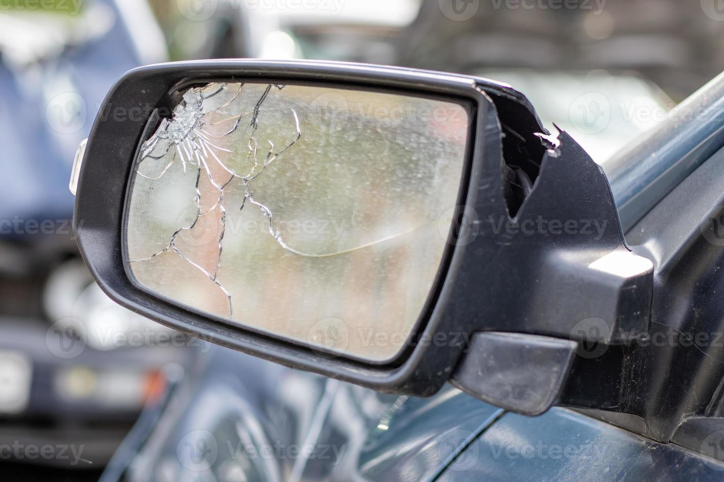 close-up gebroken linker achteruitkijkspiegel van een auto in blauw. autoverzekeringsconcept. gebroken zijruit van de auto aan de bestuurderszijde als gevolg van een ongeval. crimineel voorval. foto