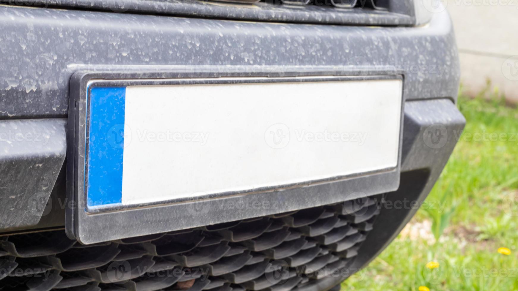 autonummer zonder letters en cijfers op de autobumper. blanco witte kentekenplaat voor de auto, alle logo's verwijderd, close-up. de voorste rechthoekige kentekenplaat van een voertuig op straat. foto