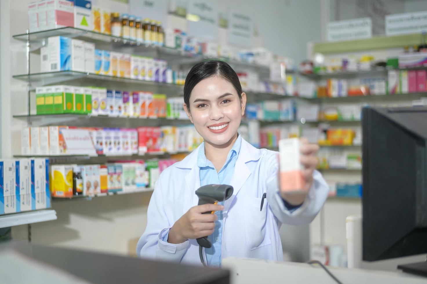 vrouwelijke apotheker die streepjescode scant op een medicijndoos in een moderne apotheekdrogisterij. foto