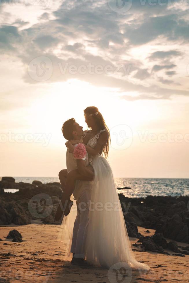 bruiloft op het strand. jong en mooi getrouwd stel in omhelzing. foto