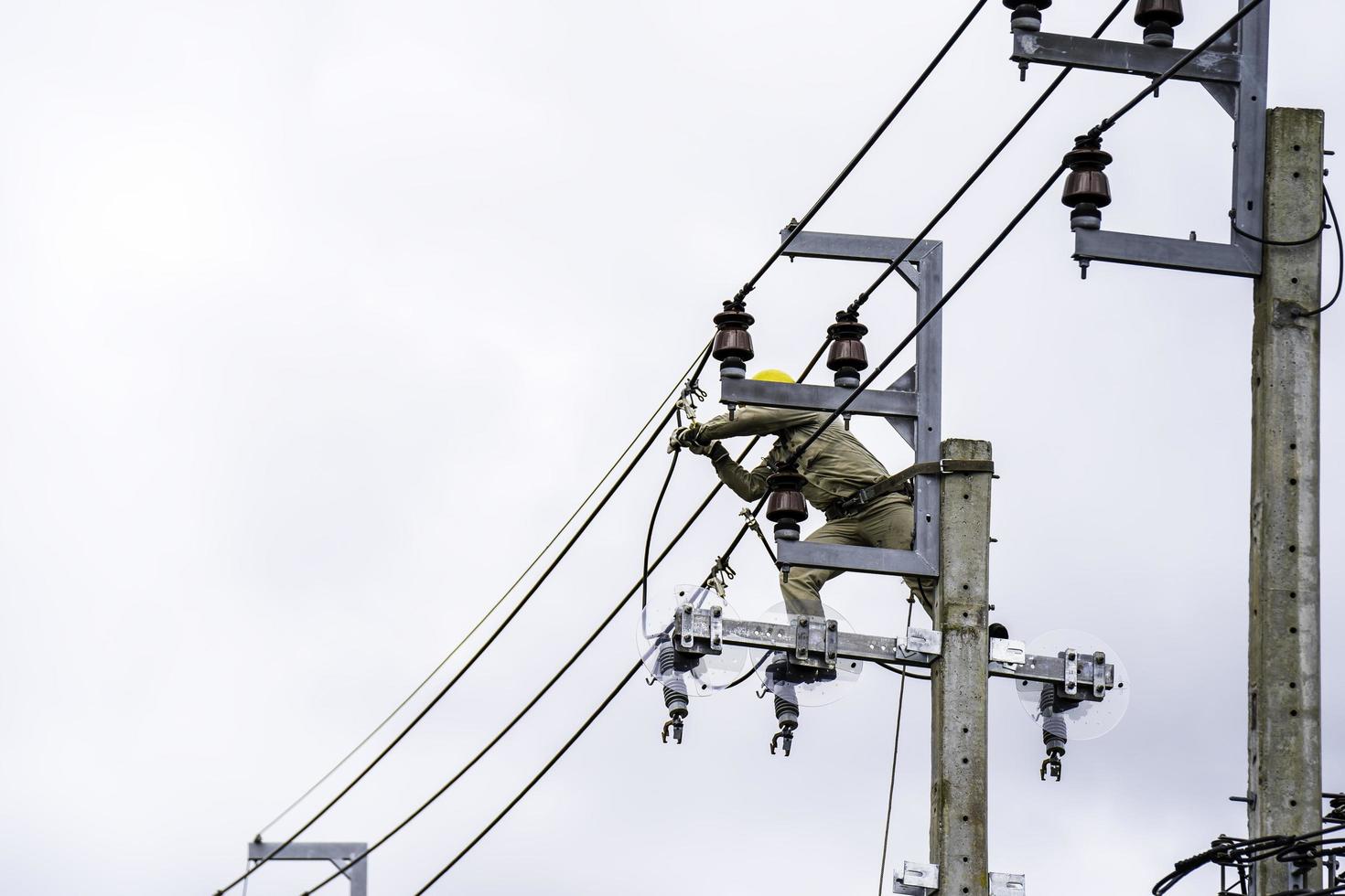 veilige en systematische installatie van elektriciens op hoogspanningspalen.werken aan elektrische palen met maximale veiligheid foto