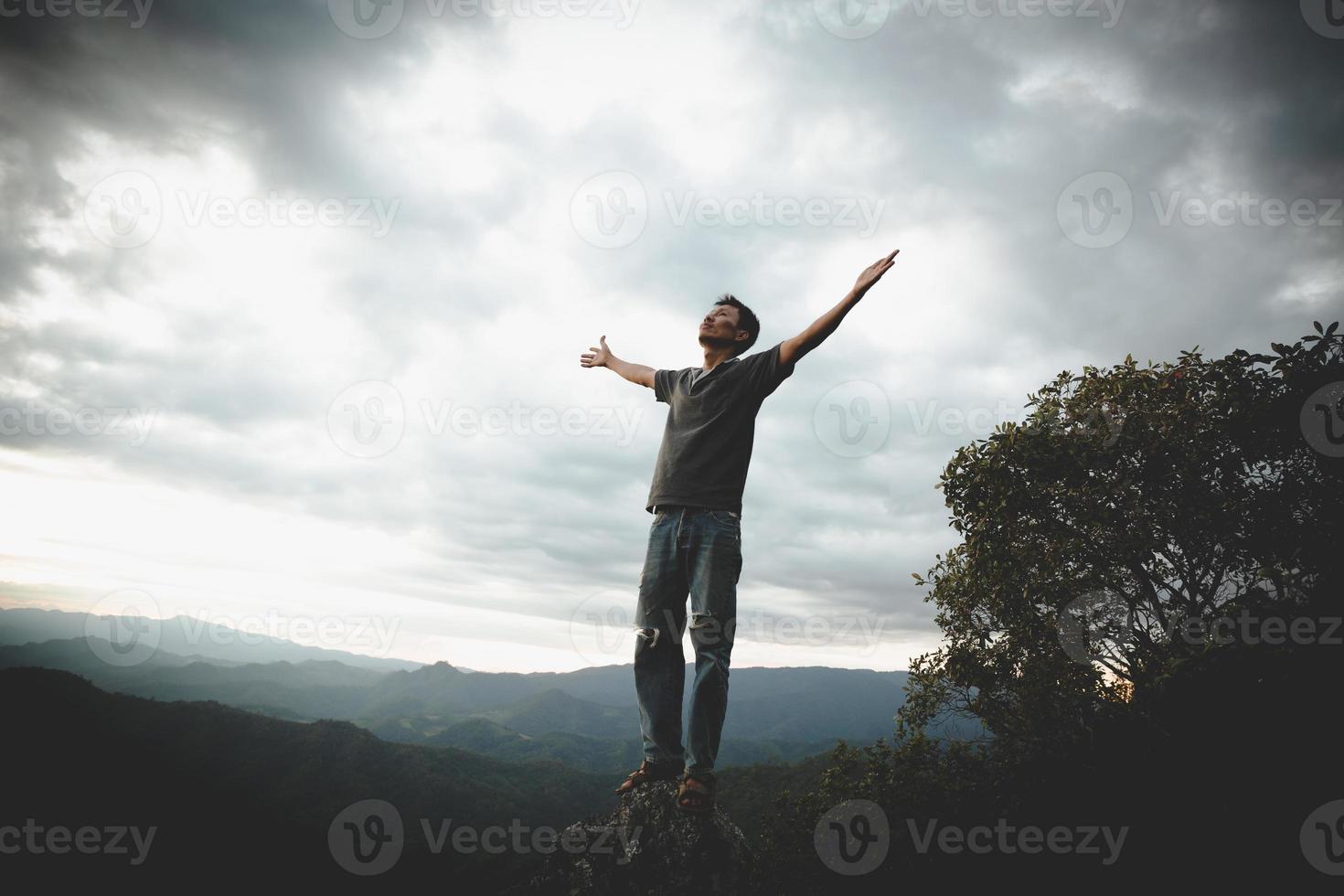 man bidden op de bergen opgeheven handen reizen levensstijl spirituele ontspanning emotioneel concept, vrijheid en reisavontuur. foto