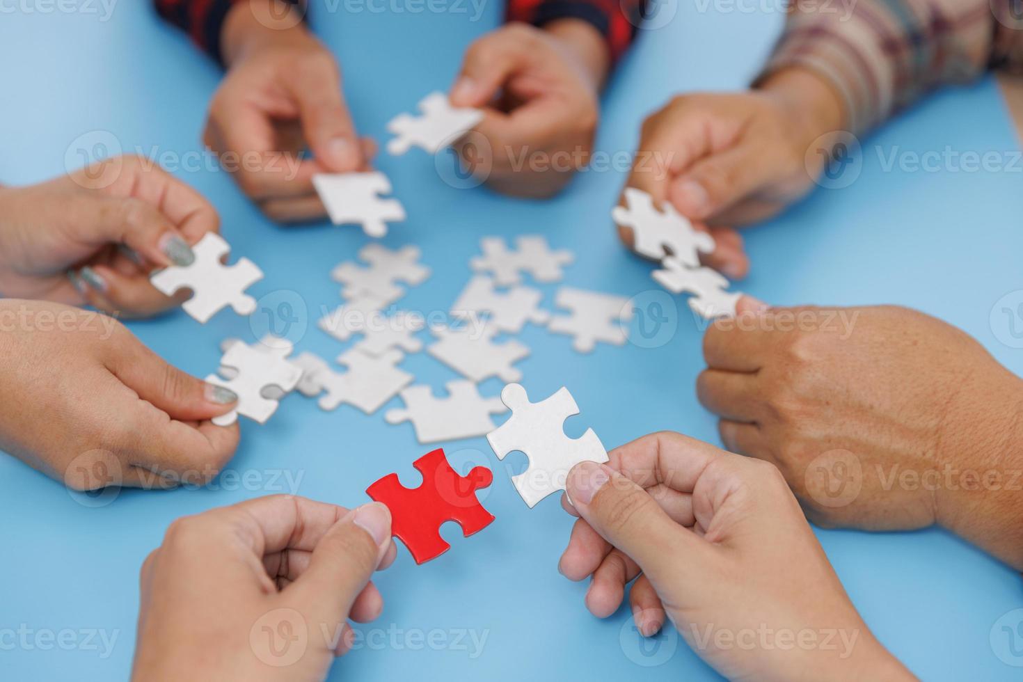 groep zakenmensen assembleren puzzels op blauwe achtergrond, teamwork, hulp en ondersteuning in het bedrijfsleven, symbool van vereniging en verbinding. Bedrijfsstrategie. foto