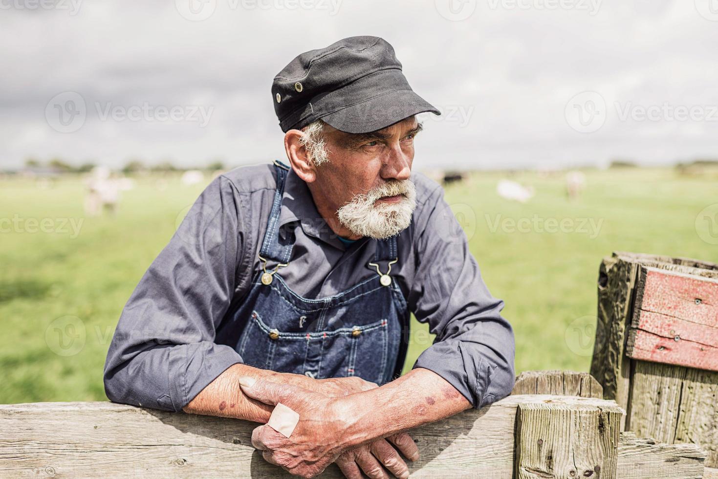 bejaarde boer onderzoekt zijn landbouwgrond foto
