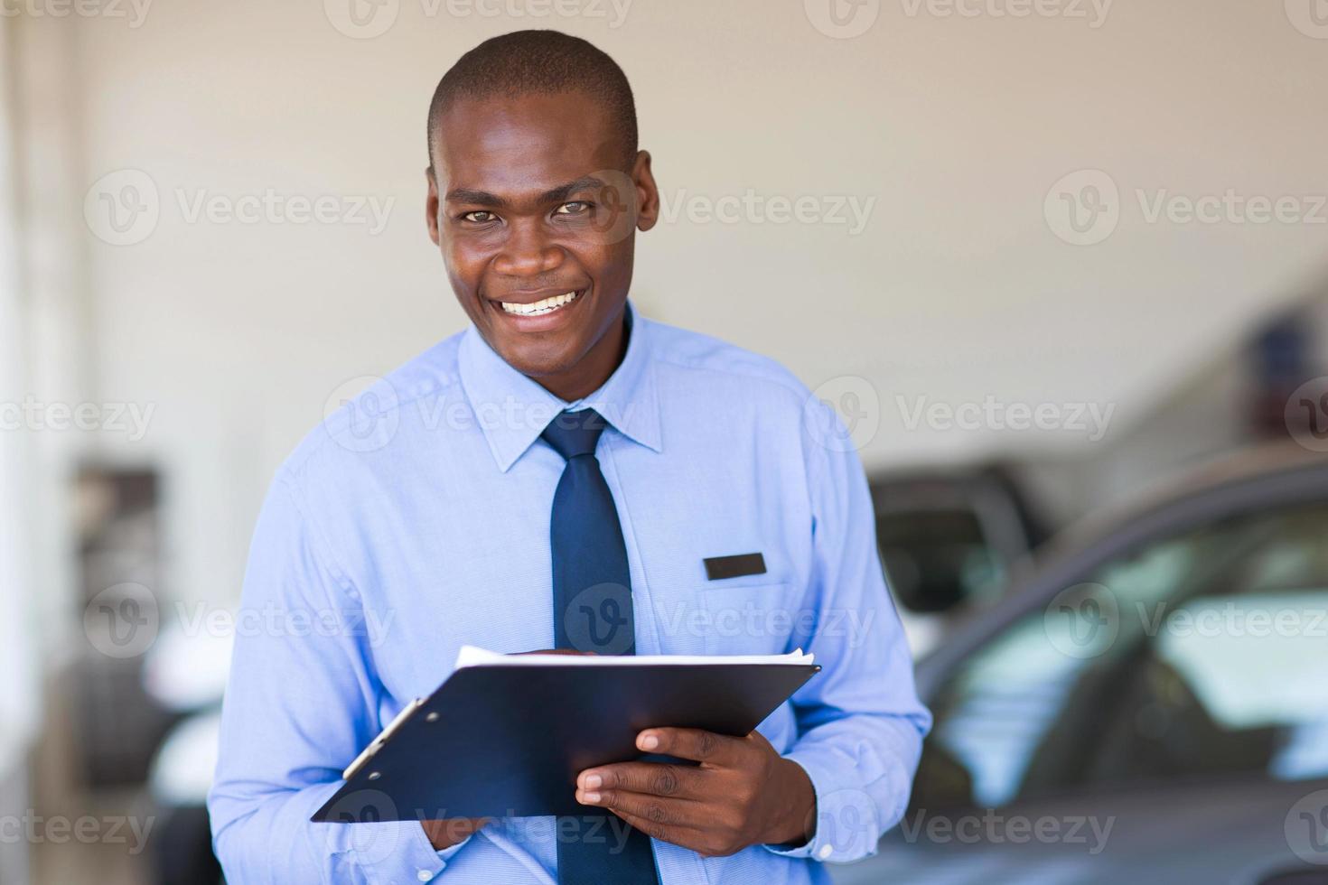Afrikaanse verkoper die bij voertuigtoonzaal werkt foto