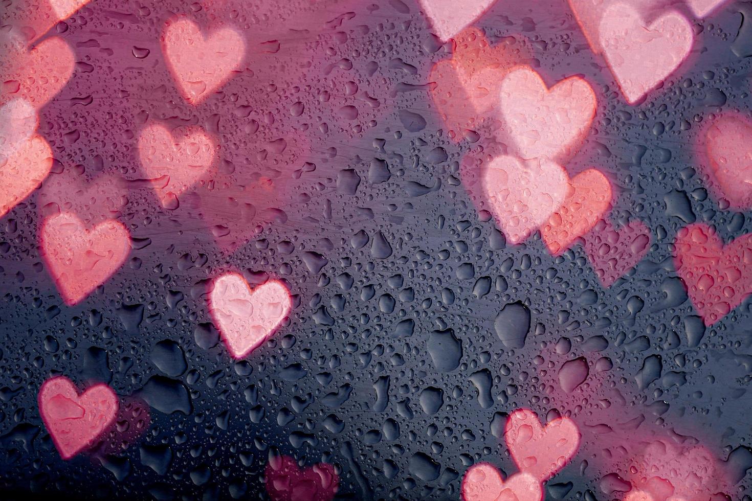 hartvorm en regendruppels op het raam foto