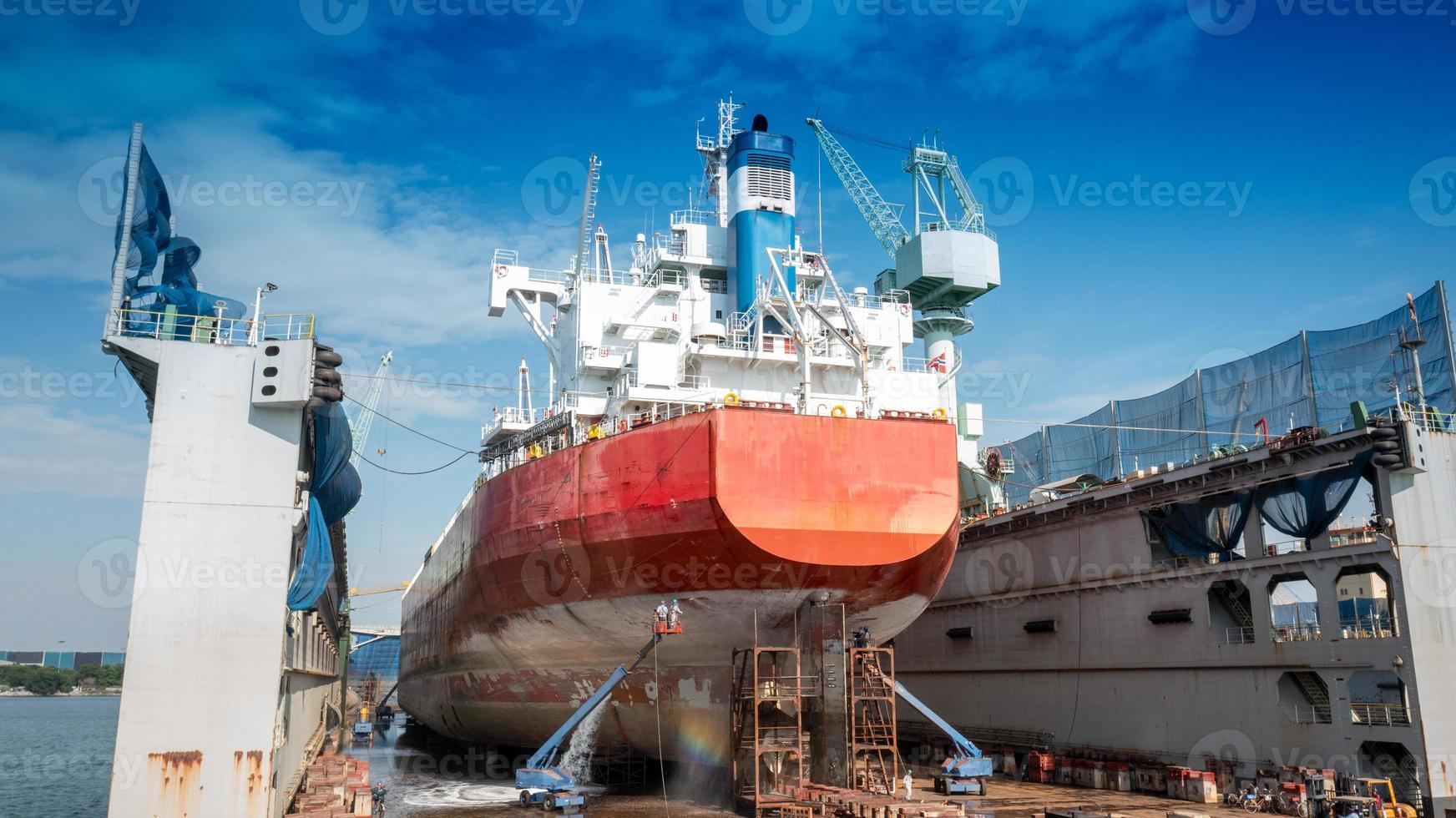 het casco schilderen bestaat uit wassen, stralen en schilderen van het schip vrachtschip door exploitant bij internationaal droogdok concept onderhoudsservice jaarlijkse schoonmaak. foto