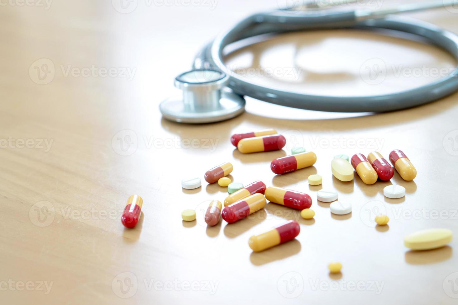 medisch concept met pillen en stethoscoop op houten tafel foto