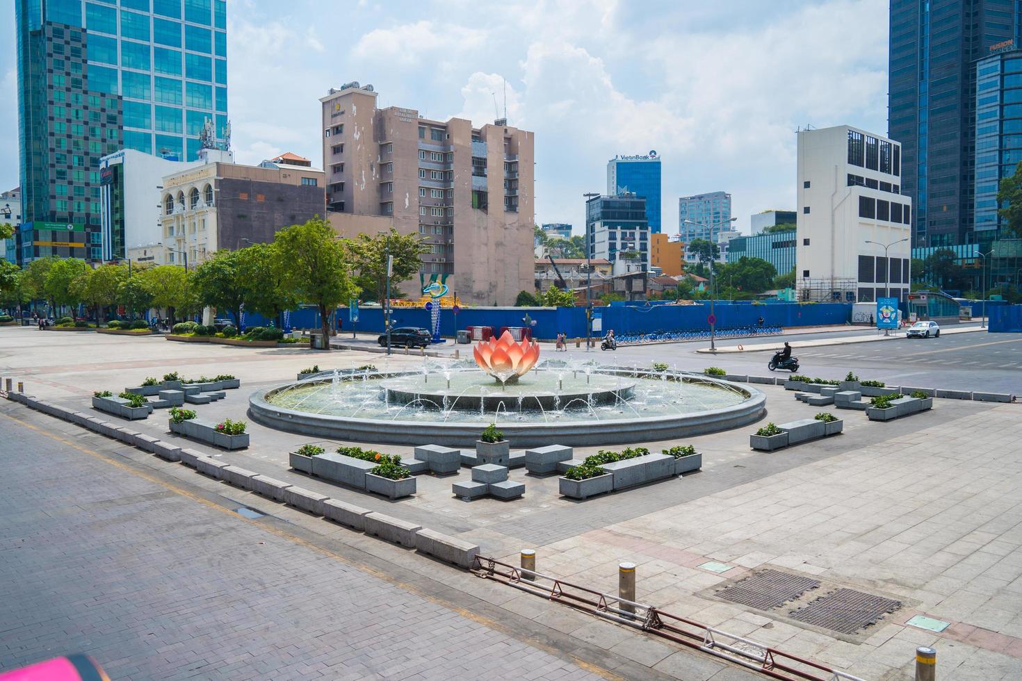 ho chi minh, vietnam 13 feb 2022 een lotusvormige fontein met mooie lichten op nguyen hue straat lopen voor ho chi minh standbeeld en ho chi minh volkscomité foto