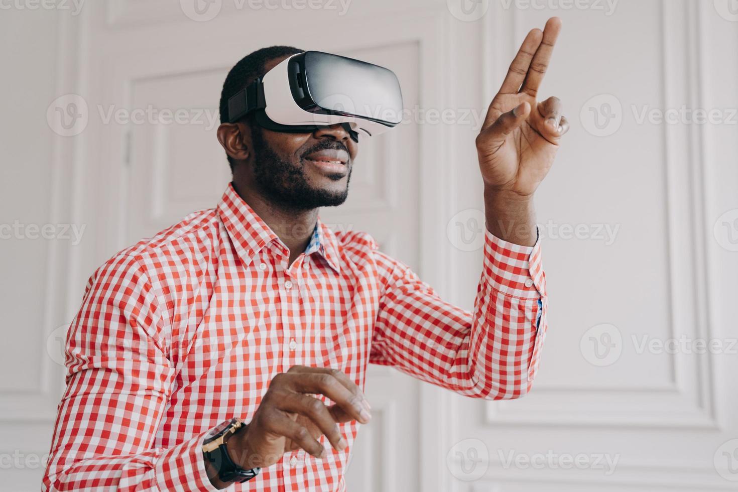 onder de indruk man van Afrikaanse etniciteit in vr-headsetbril die online geniet van virtual reality op het werk foto