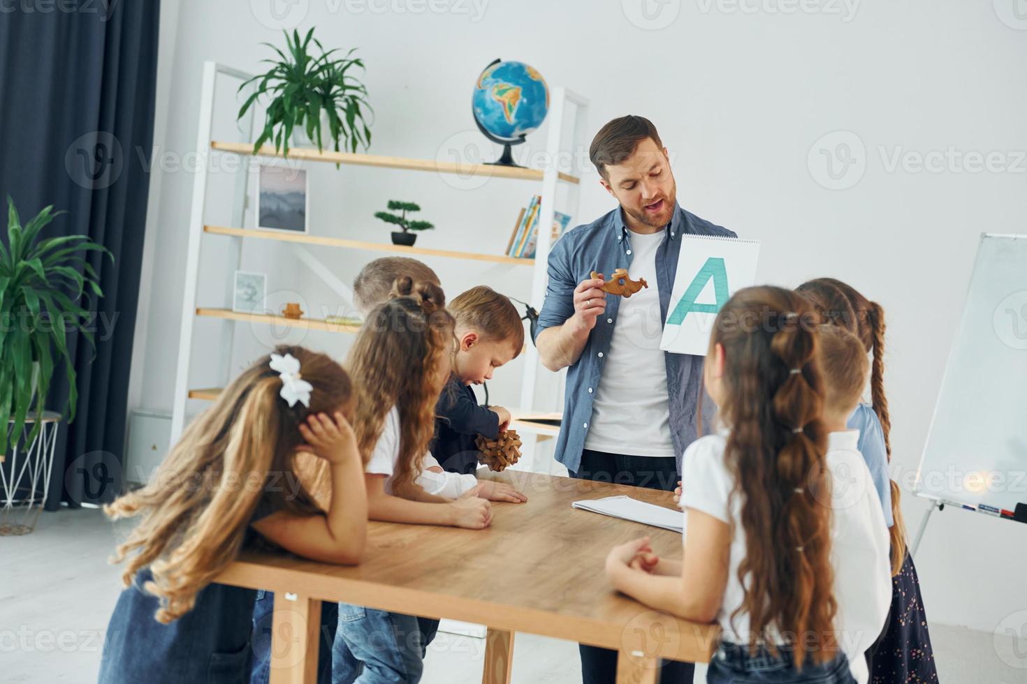 een nieuwe brief leren. groep kinderen studenten in de klas op school met leraar foto