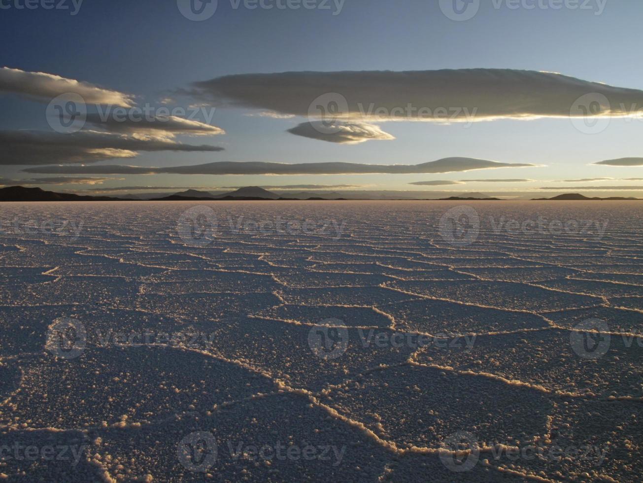 prachtige patronen op het oppervlak van de zoutvlakten van salar de uyuni, bolivia, tijdens zonsondergang foto