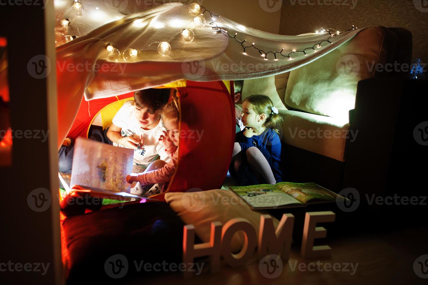 spelende kinderen in tent 's nachts thuis. hygge stemming. foto