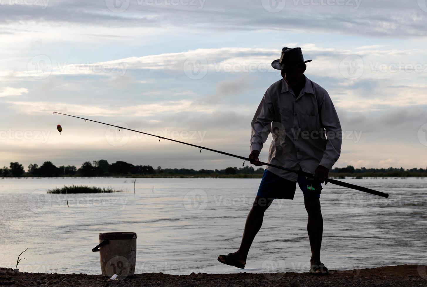 silhouet Thaise mannen permanent vissen. foto