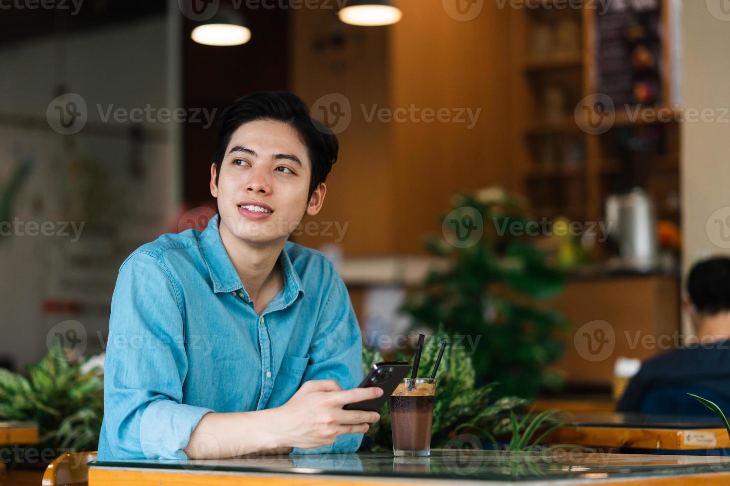 Aziatische man zit en drinkt koffie foto