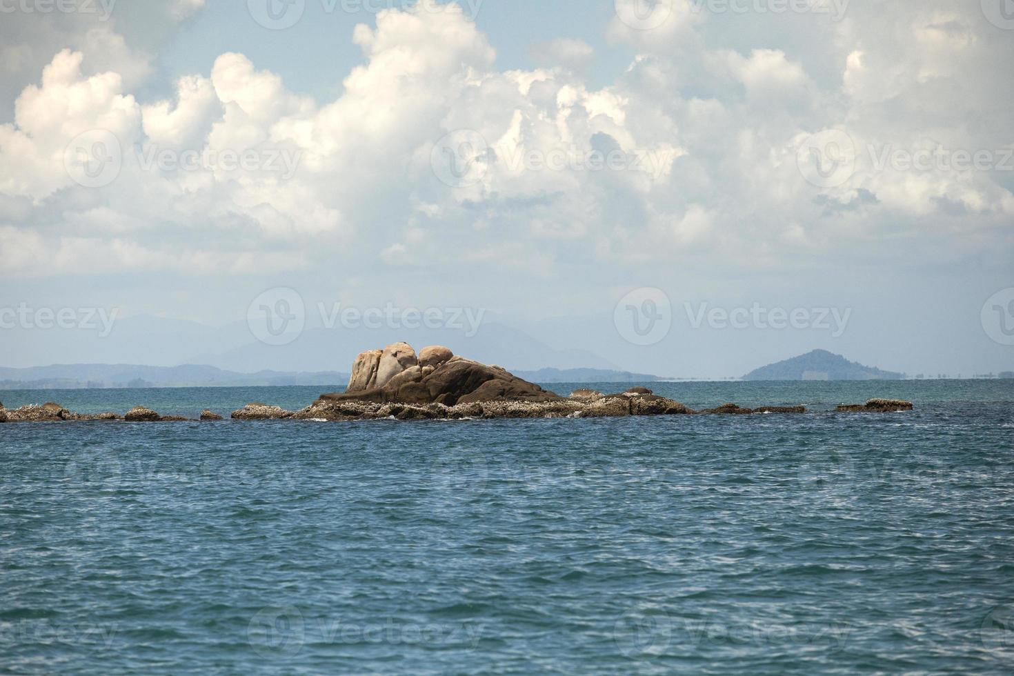 natuurlijke rots over blauwe zee in rayong, ten oosten van thailand foto