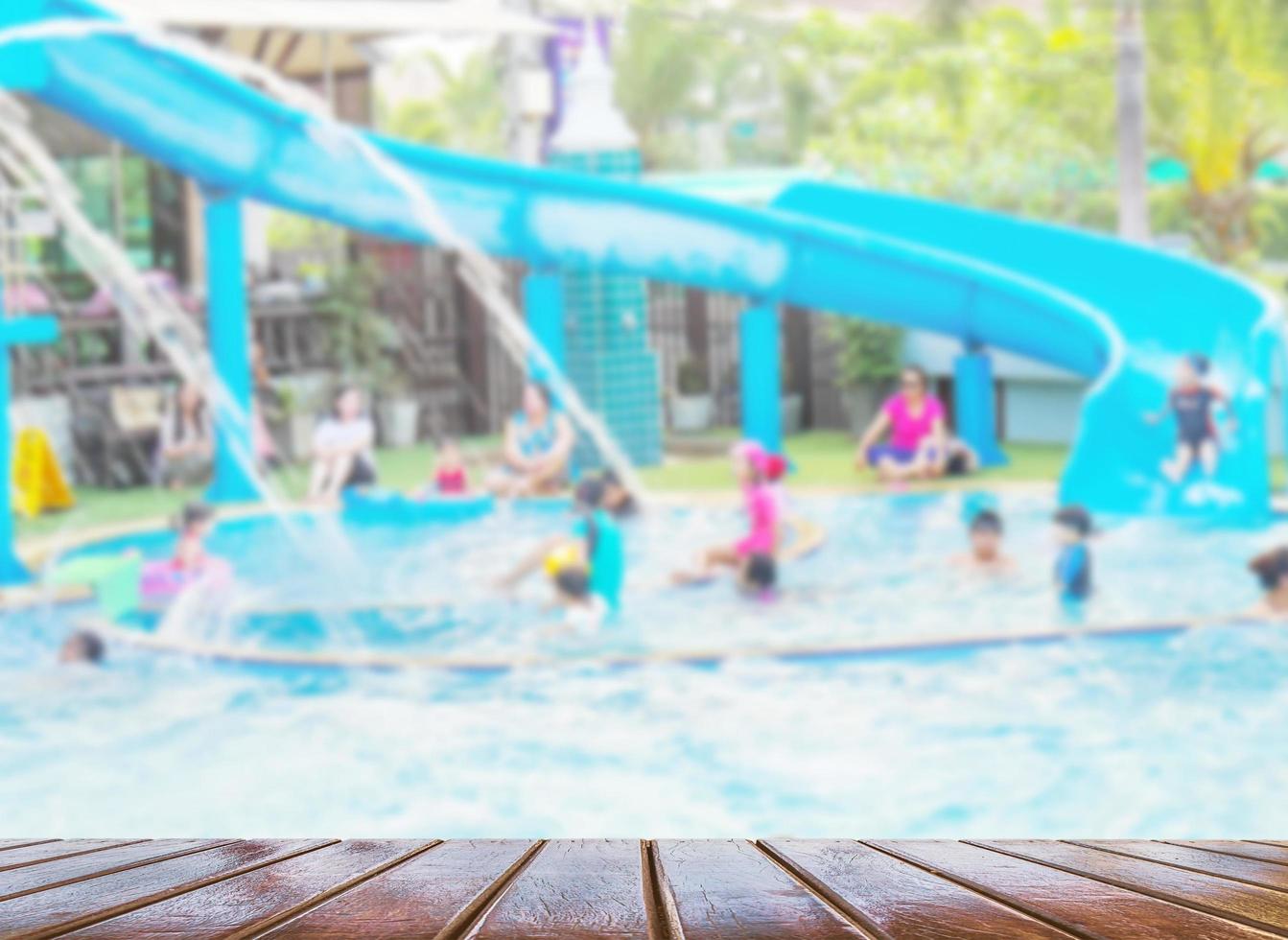 wazige foto van mensen die spelen in een zwembadpretpark met bruin houten terras