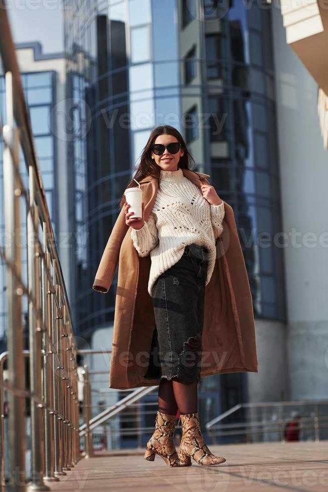 charmante hoge brunette. jong mooi meisje in warme kleren heeft in het weekend in de stad gewandeld foto