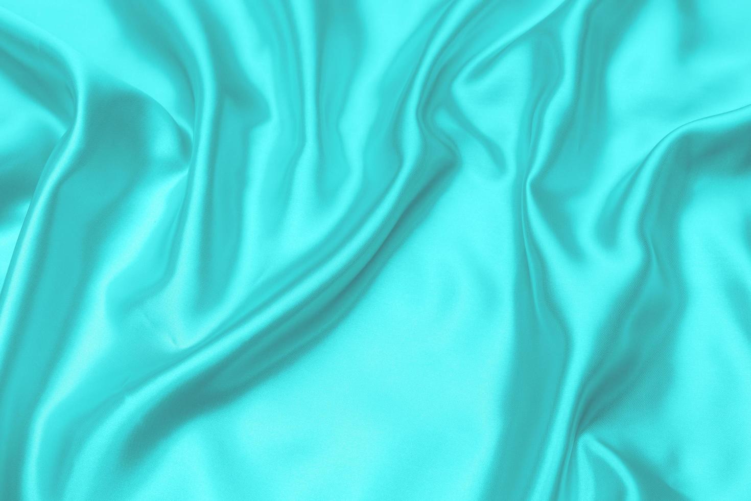 cyaan-blauwe satijnen stof textuur zachte achtergrond wazig foto
