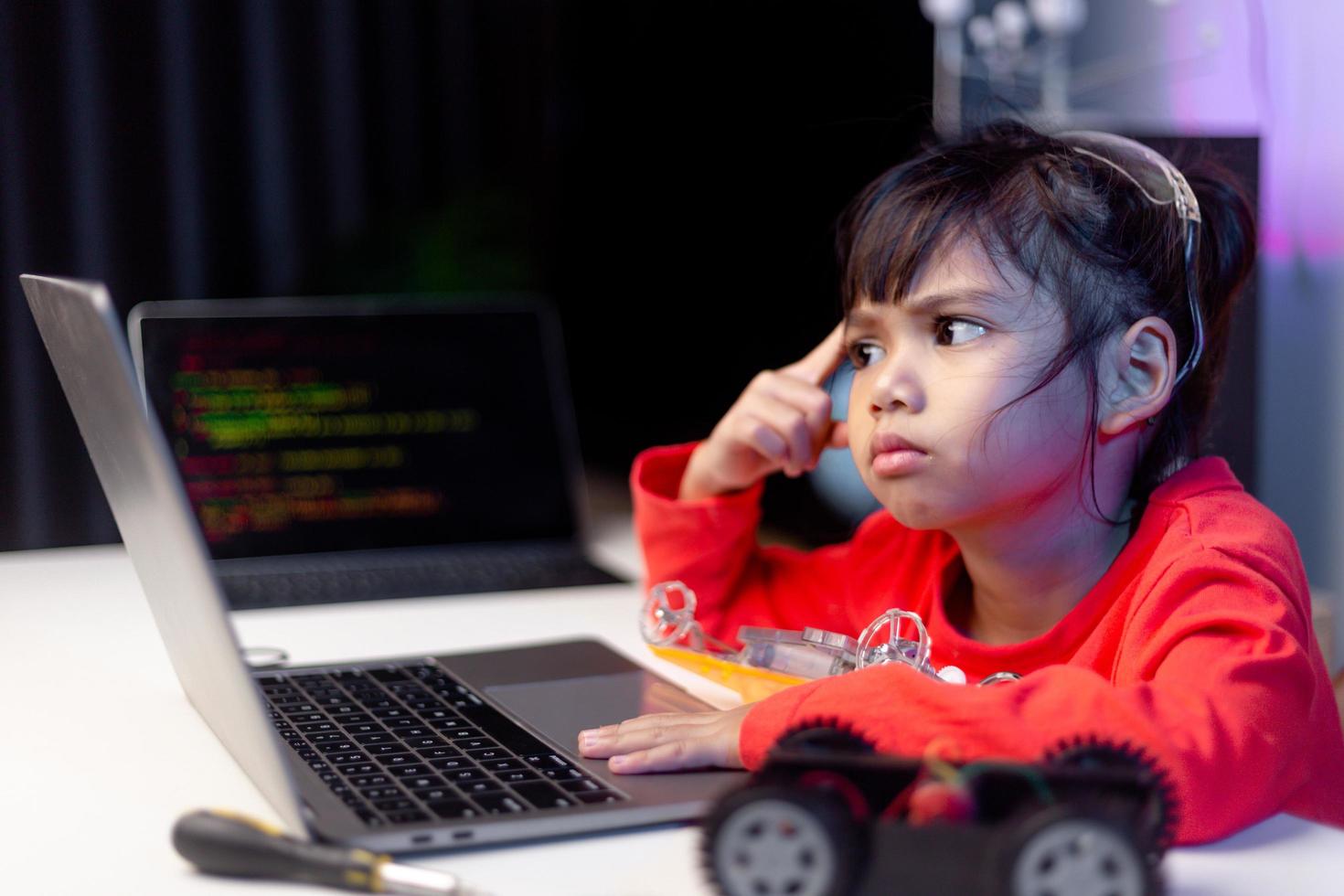 azië studenten leren thuis in het coderen van robotauto's en elektronische bordkabels in stam, stoom, wiskunde engineering wetenschap technologie computercode in robotica voor kinderen concept. foto