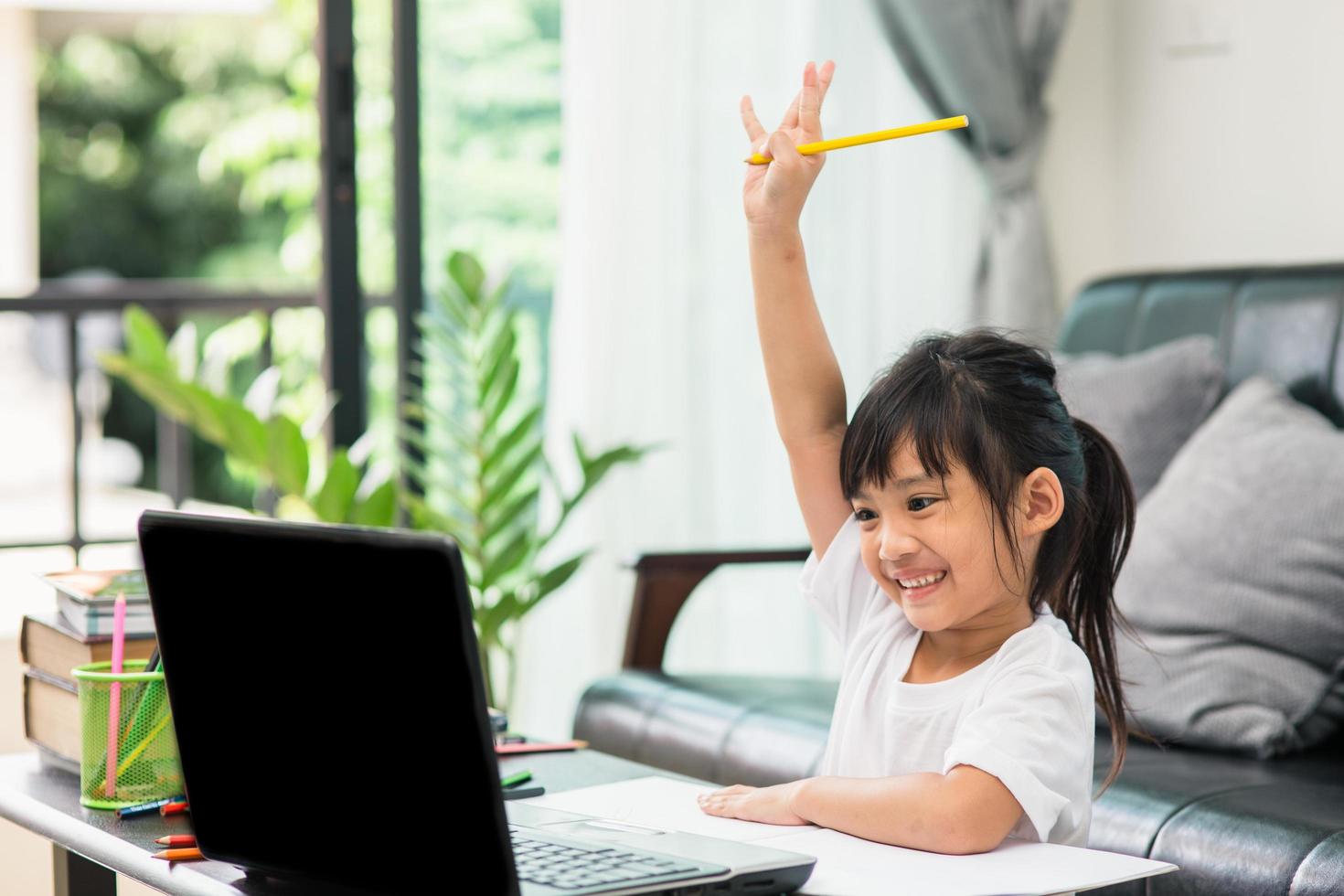 aziatische meisje student online leren klas studeren online videogesprek zoom leraar, gelukkig meisje leert engels online met laptop thuis nieuw normaal covid-19 coronavirus sociale afstand blijf thuis foto