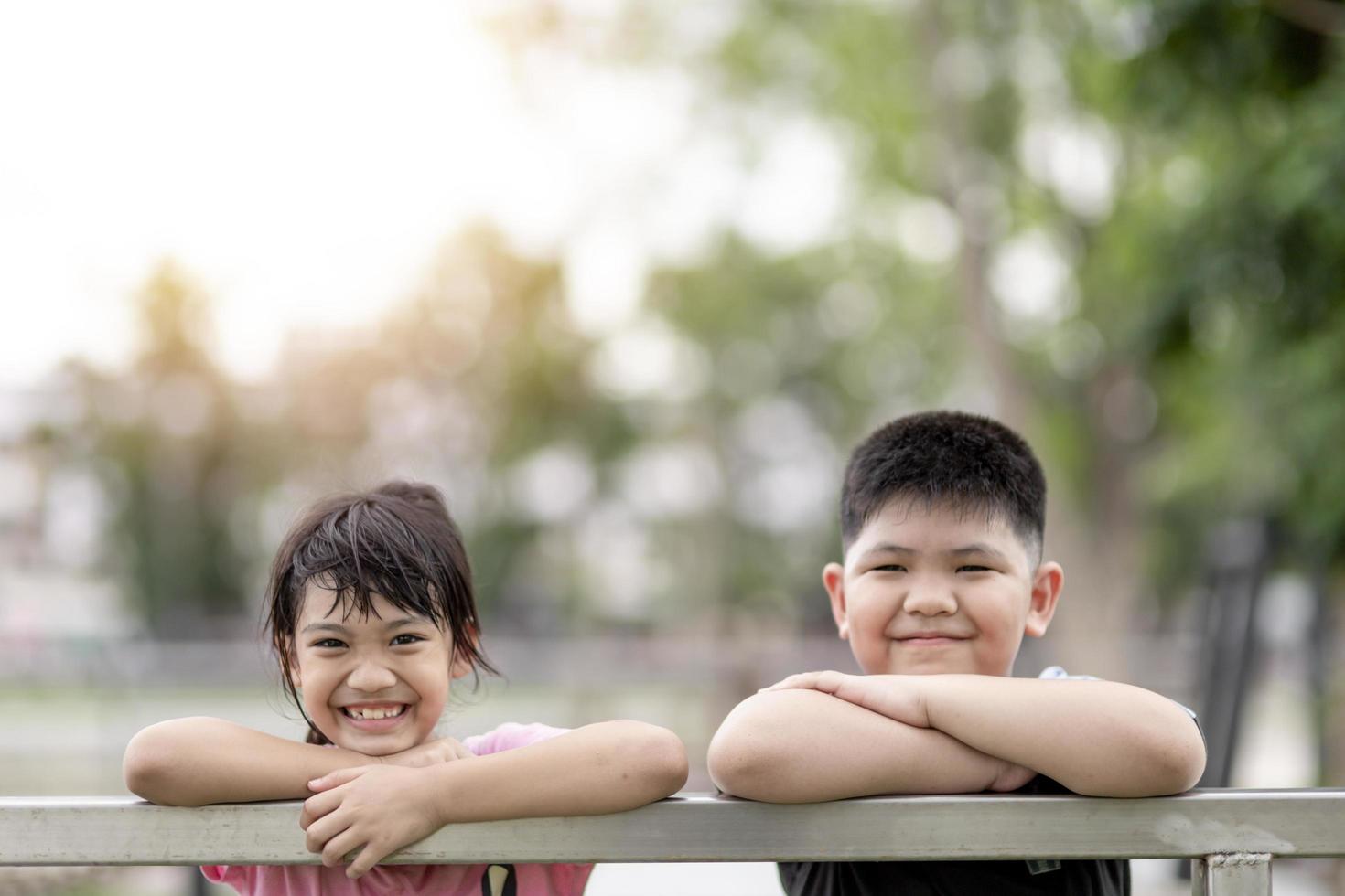 twee kleine Aziatische kinderen jongen en meisje blij en glimlach in het park foto