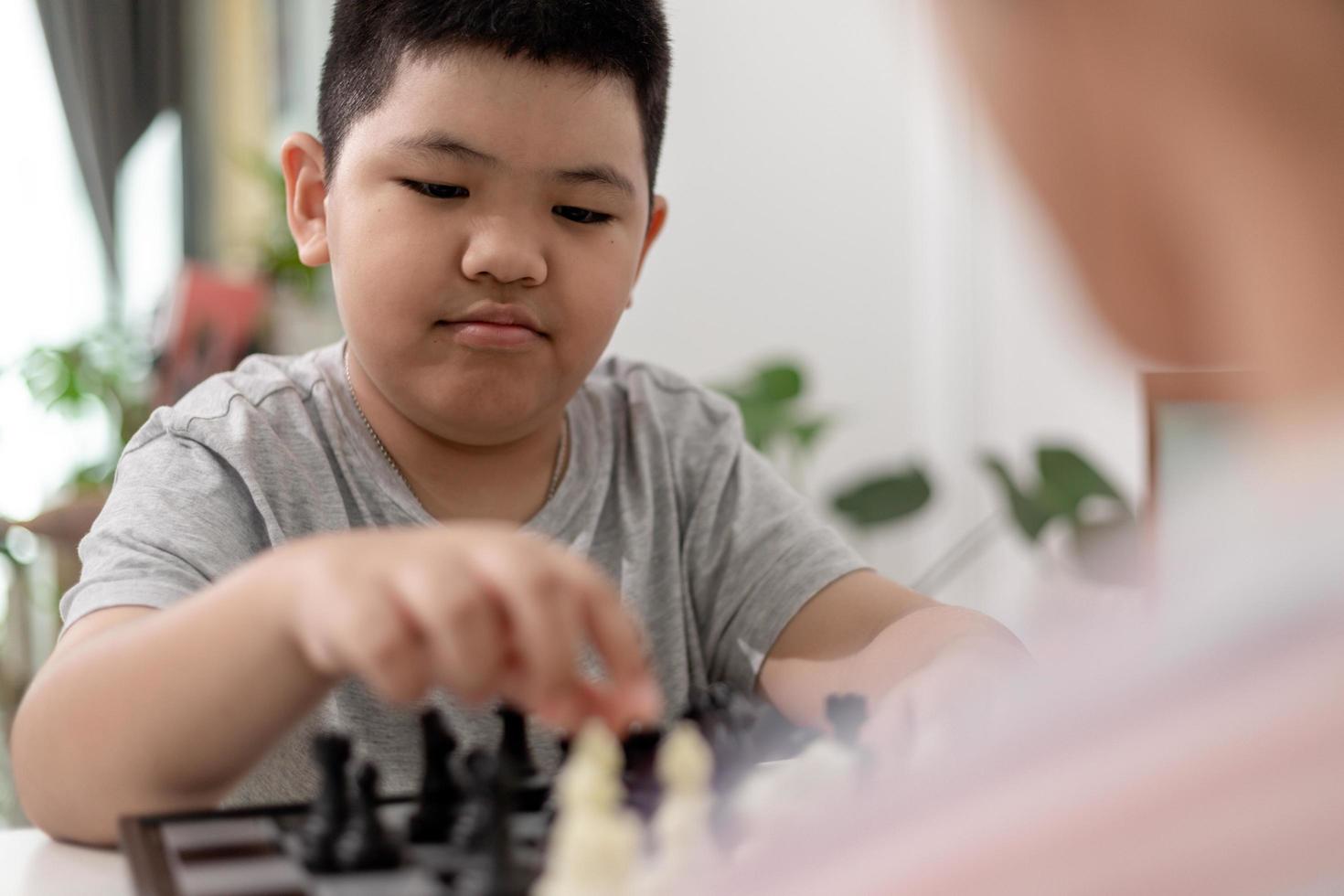 kleine jongen en meisje spelen thuis schaken. kinderen schaken foto