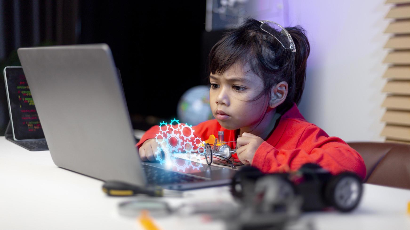 azië studenten leren thuis in het coderen van robotauto's en elektronische bordkabels in stam, stoom, wiskunde engineering wetenschap technologie computercode in robotica voor kinderen concept. foto