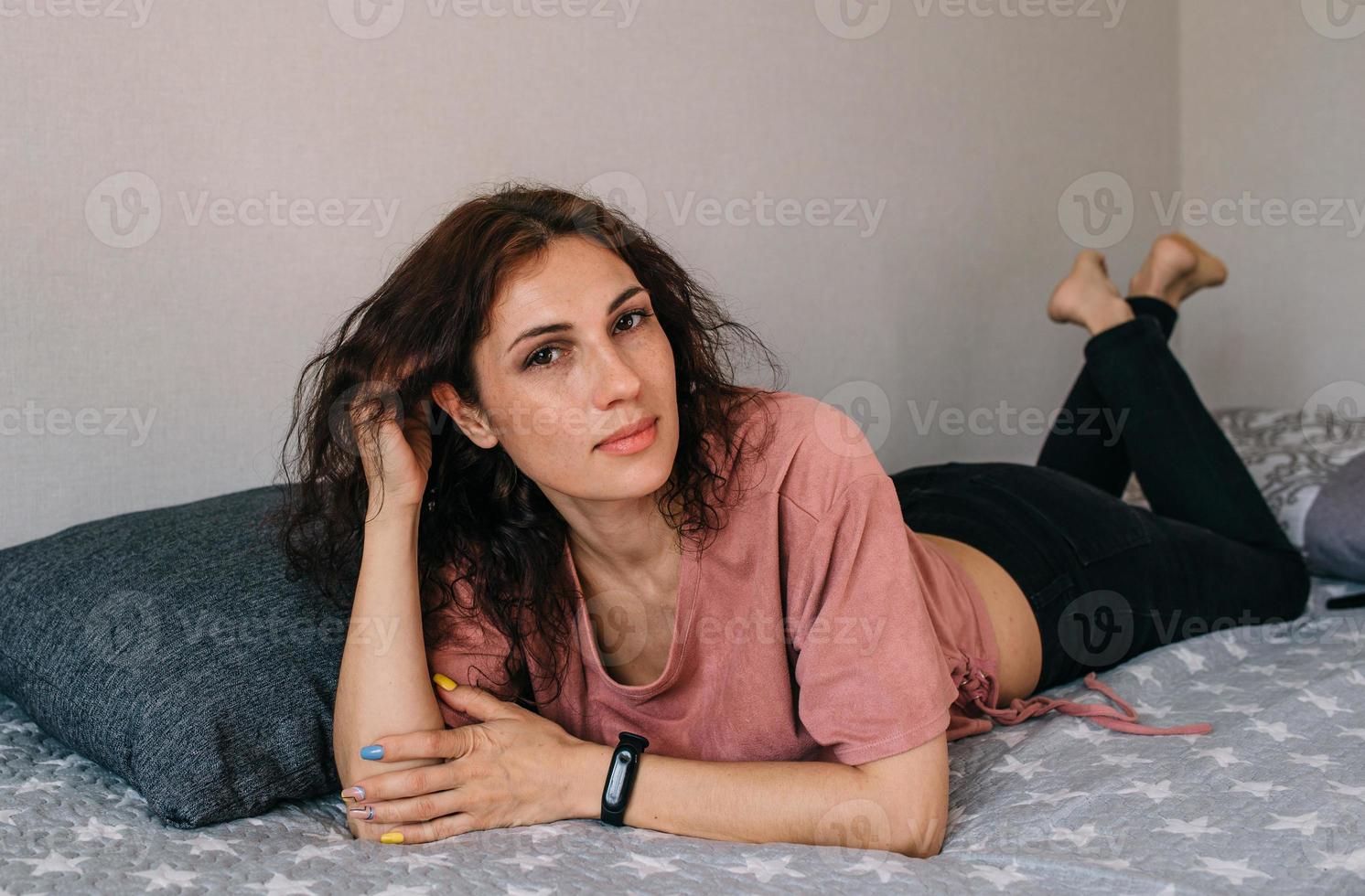 portret van een aantrekkelijke brunette vrouw die thuis poseert en naar de camera kijkt foto