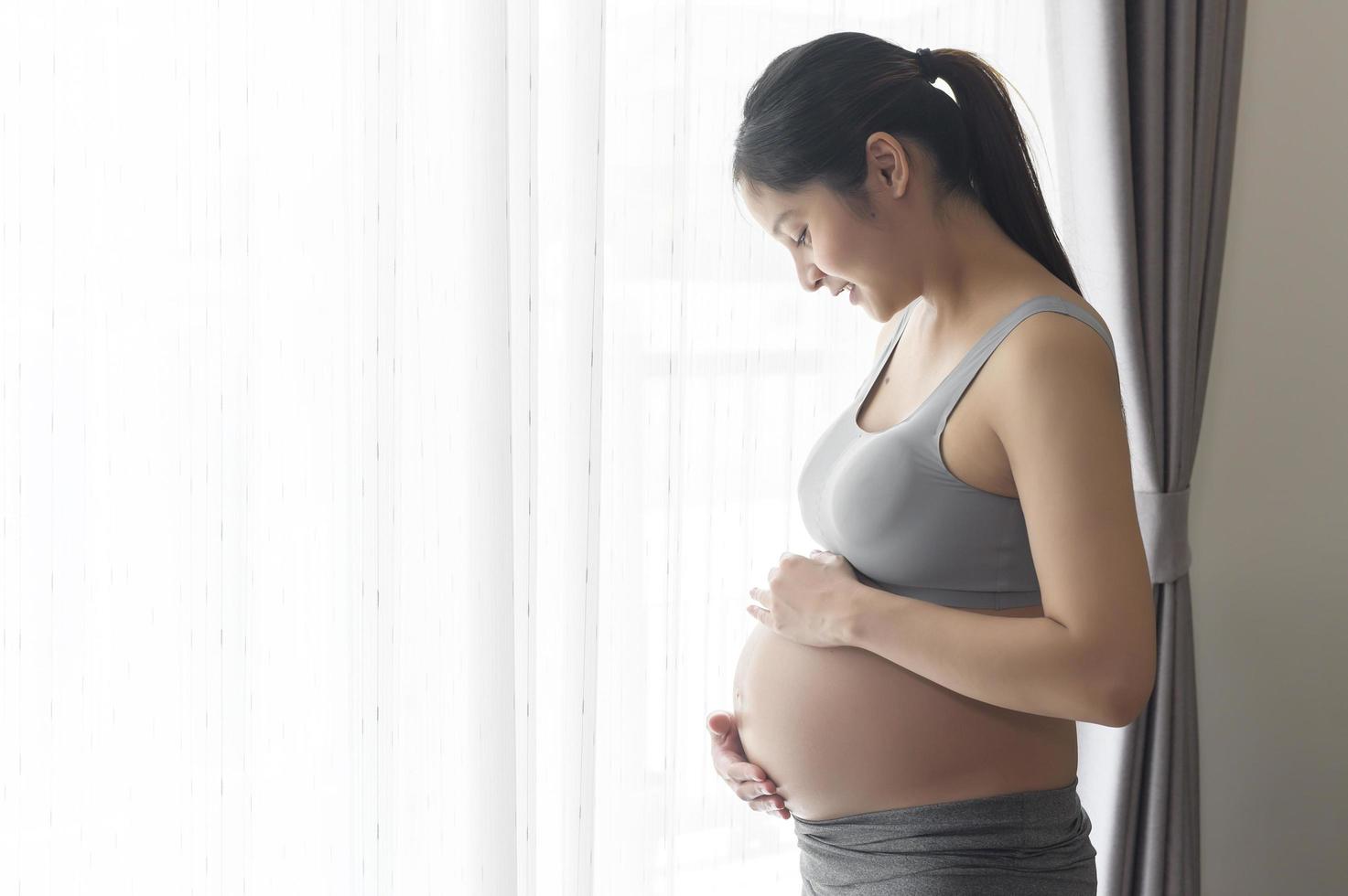 jonge mooie zwangere vrouw thuis, kraam- en zwangerschapszorgconcept foto