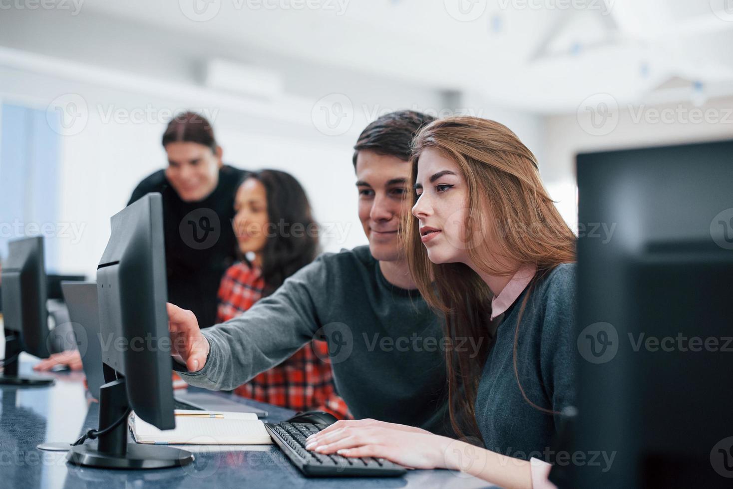 advies geven. groep jongeren in vrijetijdskleding die in het moderne kantoor werken foto