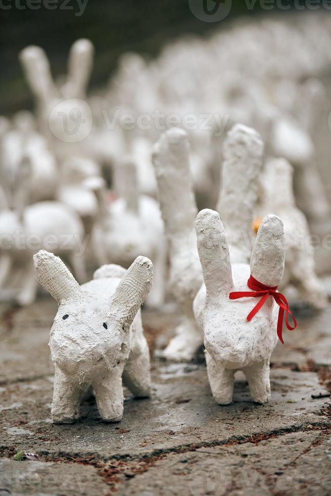 witte konijnenbeelden gemaakt van gips bij kunsttentoonstelling buiten, grappige witte hazen op straat foto