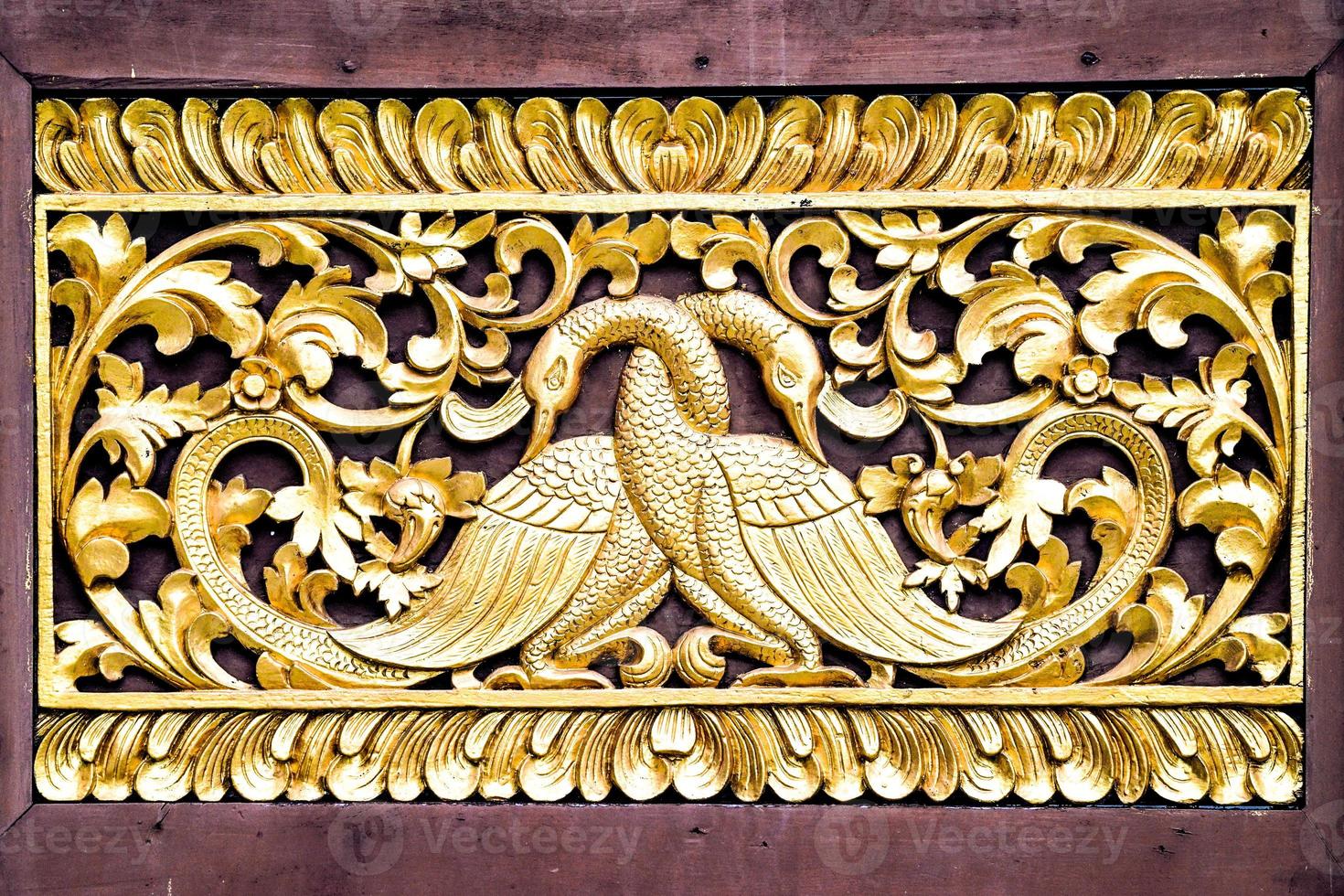 gouden paar zwaan ambachtelijke kunst met de hand gemaakt door aziatische thaise kunstenaar, installeer op de thaise tempelmuur. foto