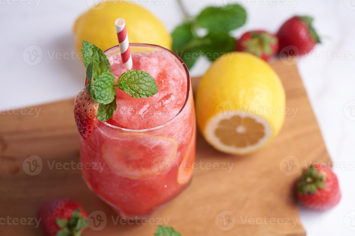 heerlijke smoothie van aardbei en citroen gegarneerd met verse aardbeien en munt in glas. zachte focus. mooi voorgerecht roze aardbei, welzijn en gewichtsverlies concept. foto