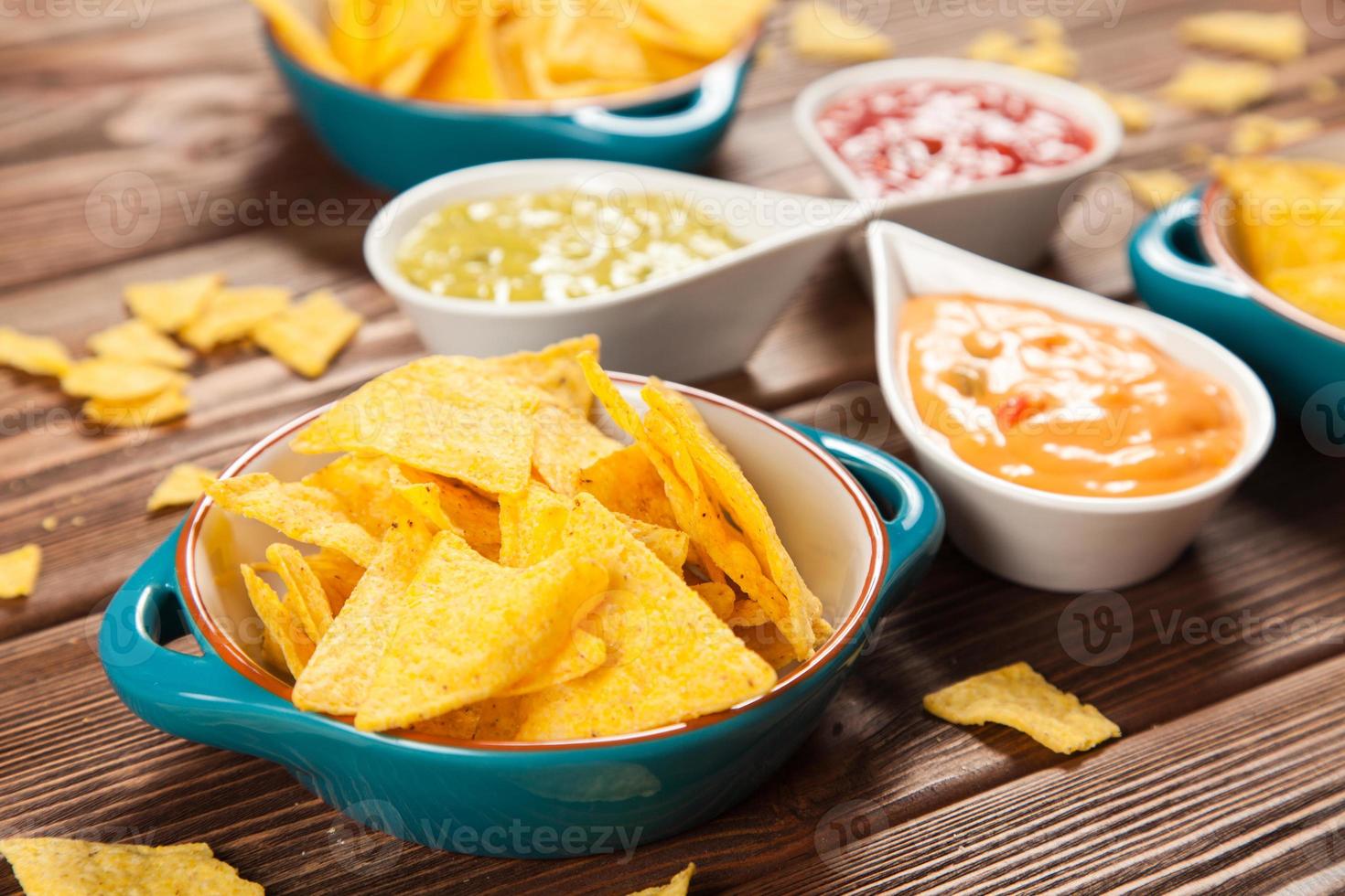 plaat van nacho's met verschillende dips foto