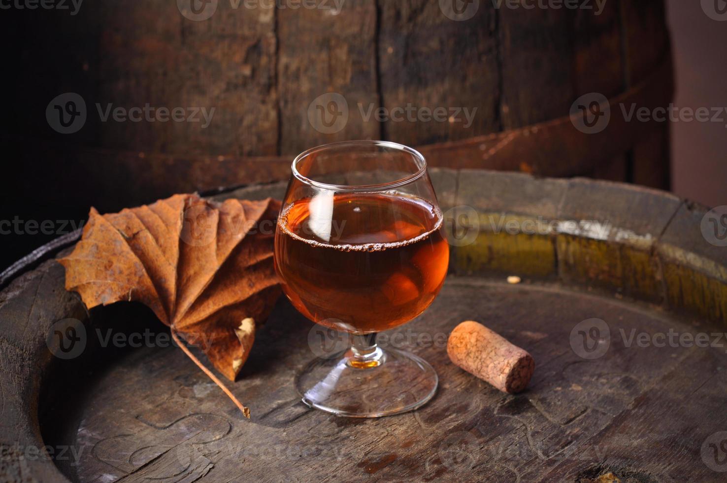 glas cognac op het vintage houten vat foto